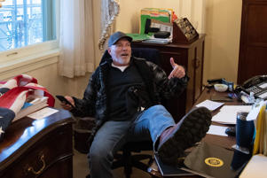 Richard Barnett sits in the office of then-President Nancy Pelosi on January 6, 2021. (Saul Loeb/AFP/Getty Images)