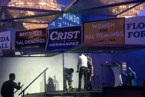 Staff prepare the stage for the last Democratic Party campaign event before Election Day in Fort Lauderdale, Fla. Gubernatorial candidate Charlie Crist and Senate candidate Val Demings were the main speakers. (Michael Robinson Chavez/The Washington Post)