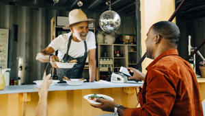 The owner is serving food to the customer