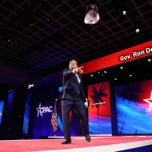 Ron DeSantis tosses hats to the crowd as he walks to the podium at CPAC at Rosen Shingle Creek and Westgate Resort on February 24, 2022 in Orlando, Florida.