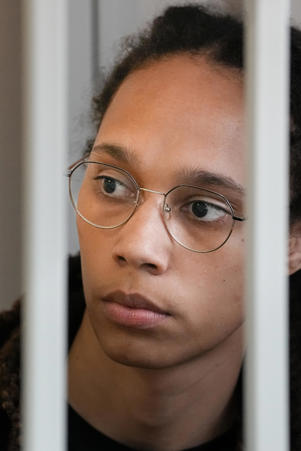 WNBA star and two-time Olympian Brittney Griner looks at the bars as she sits in the courtroom ahead of her trial on Wednesday, July 27, 2022, in Khimki, near Moscow.