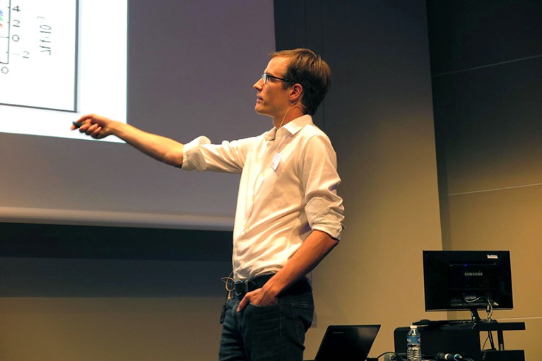 Brad Ramshaw giving a talk while using a projector.